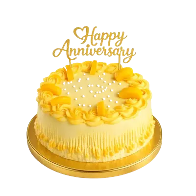 A round celebration cake with yellow frosting, textured vertical piping on the sides, and a ring of piped rosettes on top. It is decorated with sliced mango pieces, white sugar pearls, and a gold glittery "Happy Anniversary" topper.