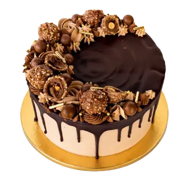 "A round cream-colored cake with a dark chocolate drip, topped with a crescent arrangement of whole and halved Ferrero Rocher chocolates, chocolate balls, and gold sprinkles."