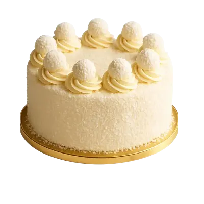 A round, elegant white cake entirely coated in shredded coconut flakes, sitting on a gold base. The top perimeter is decorated with a ring of piped cream swirls, each topped with a white coconut truffle.